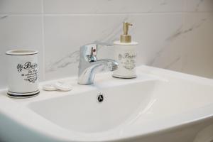 a bathroom sink with two cups and a faucet at Garden Bungalow in Kórinthos