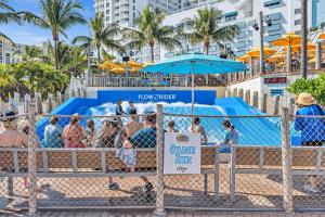 a group of people at the beach behind a fence at Studio Retreat With 2 Queen Beds Hollywood Blvd in Hollywood