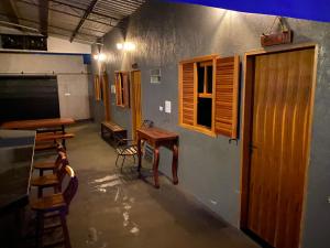 Una habitación con sillas, una mesa y ventanas. en Rancho Villa hospedagem, en Pôrto Primavera