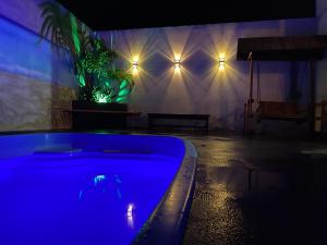 bañera azul en una habitación con luces en Rancho Villa hospedagem, en Pôrto Primavera