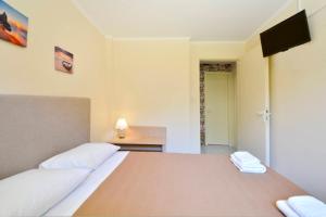 a bedroom with a bed with a television on the wall at Calm & Peaceful in Gouvia