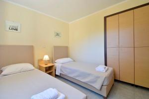 a hotel room with two beds and a cabinet at Calm & Peaceful in Gouvia