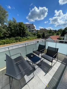 a patio with chairs and tables on a roof at Deluxe Apartment Bochum 1 BEDROOM in Bochum