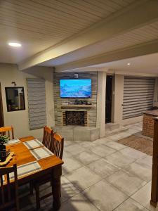 a large living room with a table and a television at Bosveld In Die Stad 2 Guesthouse in Alberton