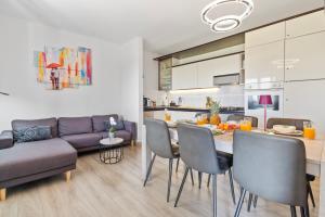 a kitchen and living room with a table and chairs at NAT Apartments in Koper