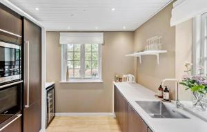 a kitchen with a sink and a window at 5 Bedroom Nice Home In Væggerløse in Marielyst +15 photos