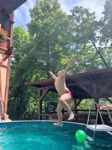 a woman is jumping into a swimming pool at Ľubochňa minidomčeky - Frodo & Bilbo in ľubochňa