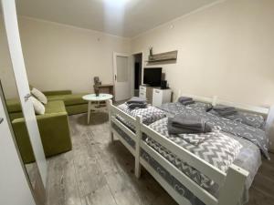una camera con due letti a castello e un divano di Apartman Lea a Paraćin