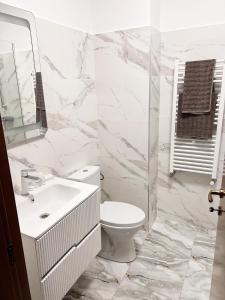 a white bathroom with a toilet and a sink at Rion Apartment in Saturn +4 photos