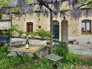 a table with a bottle of wine and two chairs at La casa di Andrea in Orvieto