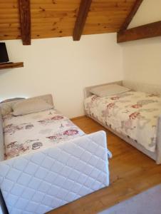 two beds in a room with wooden ceilings at Gazdų Vandens Malūnas in Navininkai +40 photos