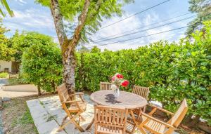 Una mesa con sillas y un jarrón de flores encima. en Cozy Apartment In Saint-Palais-Sur-Mer, en Saint-Palais-sur-Mer 15 fotos más