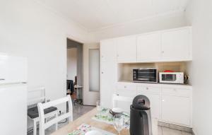 Una cocina con gabinetes blancos y un microondas. en Cozy Apartment In Saint-Palais-Sur-Mer, en Saint-Palais-sur-Mer