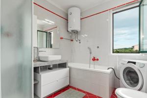 a white bathroom with a sink and a washing machine at NAT Apartments in Koper