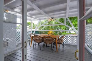 a porch with a wooden table and chairs at New Rose Retreat - Pool & Parking in Key West
