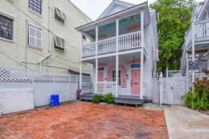 a white house with a porch and a white fence at New Rose Retreat - Pool & Parking in Key West