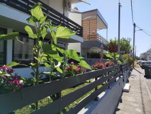 a fence with flowers and plants in front of a building at Villa Olympia in Paralia Katerinis