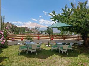a patio with tables and chairs and umbrellas at Kazdar Villa in Leh