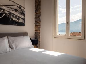 a bedroom with a bed and a window at Casa Giorgio Luxury apartment with Stunning View in Menaggio +46 photos