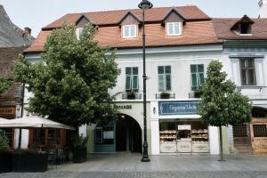 Un edificio blanco con una farola frente a una tienda. en MOLDOs Haus, en Sibiu