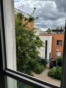 - une vue sur un arbre depuis une fenêtre dans l'établissement Petit appart, à Garges-lès-Gonesse