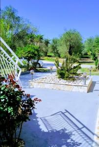 a garden with a white staircase and some plants at Trousas Apartments in Roda