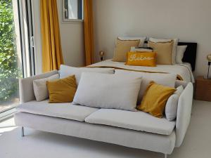 a couch with pillows on it in a living room at La Maison l'Oliveraie in Lunel +14 photos