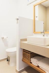 a bathroom with a sink and a toilet and a mirror at La Floristería Zahora in Zahora