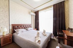a bedroom with a bed with animal towels on it at Hotel Anor in Samarkand +59 photos