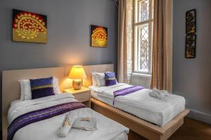 a bedroom with two beds and a window at Andrassy Thai Hotel in Budapest