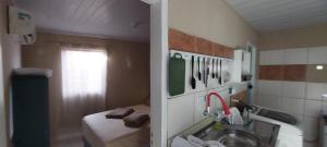 a small bathroom with a sink and a bed at Casa temporada Araçoiaba in Araçoiaba