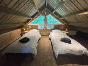two beds in a room with a large window at Vakantiehuizen voor 12 personen in Soesterberg