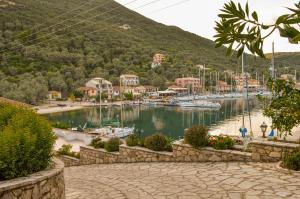 a marina with boats in the water and buildings at Sivota Bay in Sivota