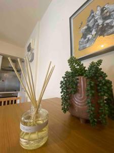 Dos plantas en un frasco de vidrio sobre una mesa. en 37chats studio, en Londres