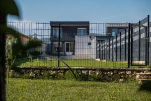a fence in a field with a building in the background at Villa Verona in Mostar