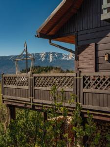 a house with a deck with a mountain in the background at Alemiło - uroczy dom z balią i widokiem na Babią Górę in Zawoja