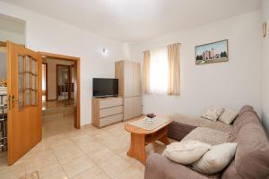 een woonkamer met een bank en een televisie bij Apartment Marta in Maslenica