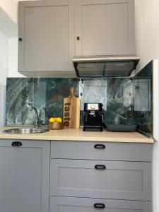 a kitchen with white cabinets and a sink at Yaya house in Skala Sotiros +6 photos