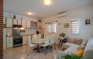Una cocina y una sala de estar con una mesa y un sofá. en Holiday Home Podaspilje I, en Svinišće