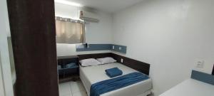 a small bedroom with a small bed with blue sheets at Casa temporada Araçoiaba in Araçoiaba