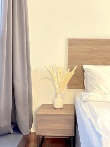 a vase on a night stand next to a bed at The Latrobe - Bangsar Trade Centre in Kuala Lumpur