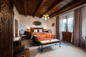 a bedroom with a bed and a couch and a table at Penzión Villa Breza in Smokovce