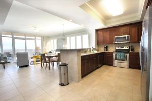 cocina grande con armarios de madera y comedor en Phoenix Gulf Shores 1901 by Liquid Life, en Gulf Shores