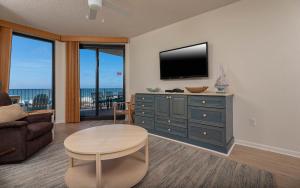 a living room with a television and a table at Phoenix X 212 condo in Orange Beach