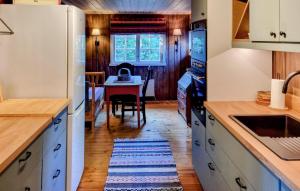 a kitchen with white cabinets and a table with a kitchen rug at Månebu in Tunhovd