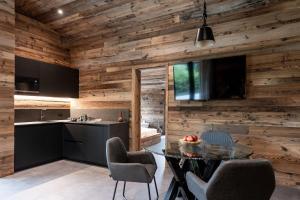 a kitchen and dining room with wooden walls at Ledarix Charm Chalet in Ledro +26 photos