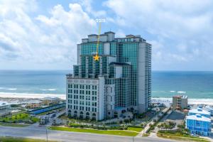a tall building with a star on it next to the ocean at The Oasis At Orange Beach 2215 by Liquid Life in Orange Beach
