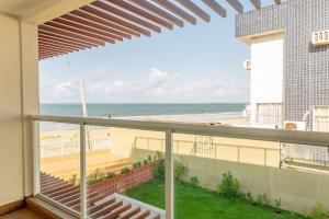 a balcony with a view of the beach at Qavi - Flat Vista Mar de Pirangi #Living14 in Pirangi do Norte