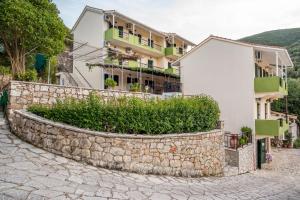 a building with a stone wall next to a street at Sivota Bay in Sivota +8 photos