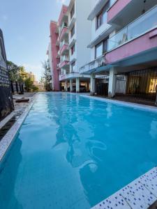 una mujer nadando en una piscina frente a un edificio en NYALI-TWO BEDROOM FULLy FURNISHED APARTMENT WITH A BEACH VIEW, en Mombasa
